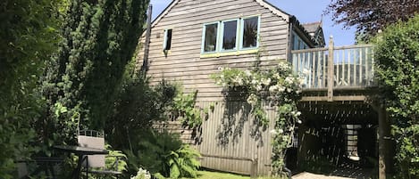 Looking up at the Boathouse from the garden, with small patio area outside