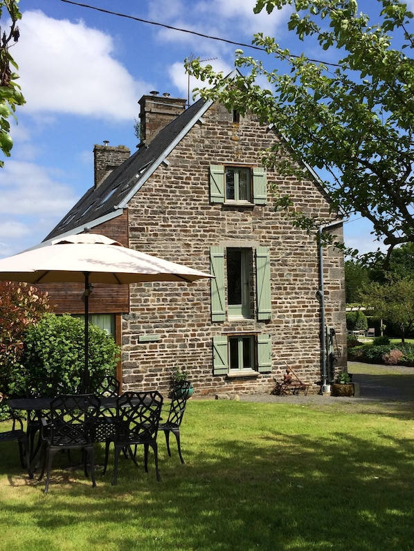 Private seating area in the orchard showing Gite exterior