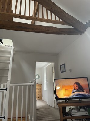 Double height ceilings upstairs with exposed beams 