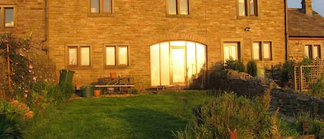 The rear of Midsummer Barn Holiday Cottage in a glorious sunset