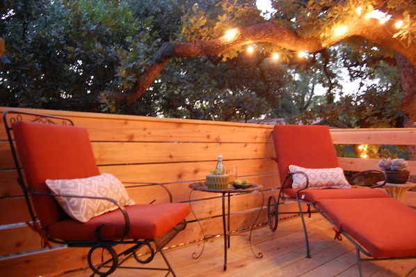 Our treetop studio has a private deck under the trees that is lit up at night
