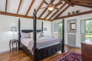 Primary Bedroom overlooking courtyard with king bed, TV, & leather reading chair