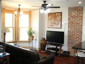 Living room featuring original wood trim, brick and Brazilian Cherry flooring