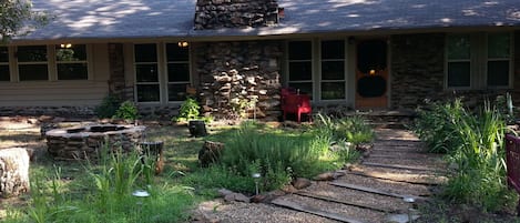 Cabin Exterior. Front herb beds and stone fire pit.