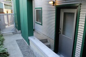 Entrance door is the first gray door, the next one will be the laundry room.