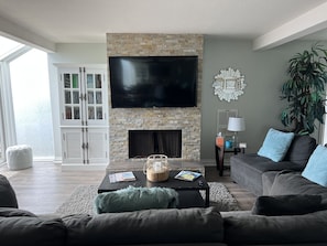 Family room offers comfortable seating area with 60" TV.  Games, books, and Roku