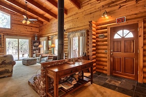 Rustic log cabin with a wood stove and warm wooden furnishings.