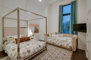 Discover our spacious bedroom adorned with an elegant queen-sized canopy bed, complemented by a twin bed featuring a convenient pullout trundle. Perfect for both relaxation and serene nights of rest.
