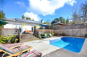 Relax on teak outdoor loungers. Enclosed yard provides total privacy.