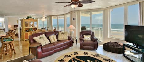 Sit in the living room with panoramic views of the ocean and beach.