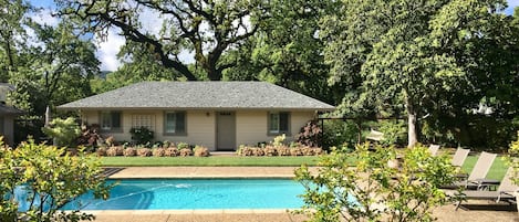 The cottage is in a landscaped pool courtyard across from the main house