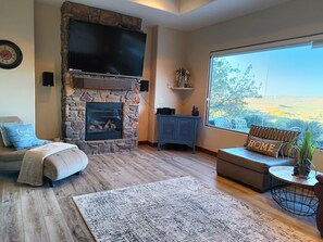 living room with large smart TV and picture window.