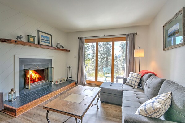 Living room with fireplace, fold-out couch and walk out back porch