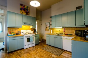 Kitchen fully stocked for cooking, w/ gas stove, microwave, coffee pot & fridge.