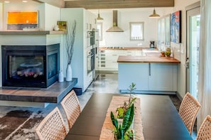Wrap around fireplace opens onto kitchen, dining and living room.
