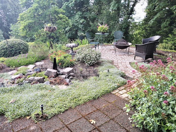 Open patio, fire pit and rock garden off of covered patio