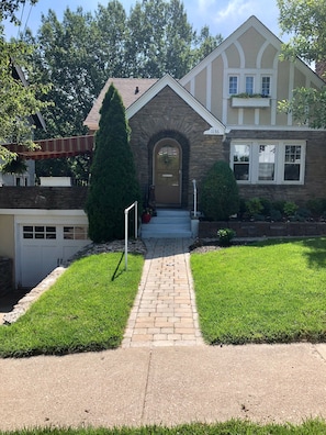 Home with two parking places in front and driveway. Handrail along sidewalk.
