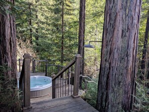 The hot tub set in the middle of a tranquil ring of redwood