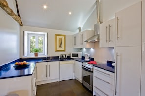 Fitted kitchen including washing machine, dishwasher and microwave oven.