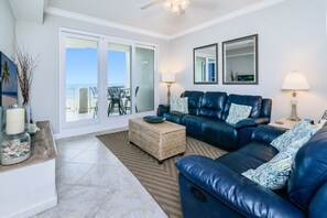 Oceanfront family room opens to a huge private balcony, comfortable couches.