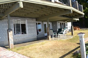 Entry patio w/table; bedroom window on left; living at center; kitchen on right