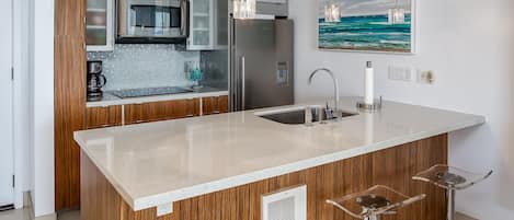 Fully stocked modern kitchen with cooktop, convection oven, dishwasher & fridge