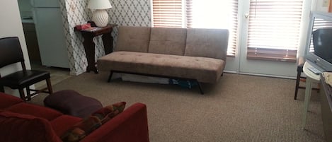 View of Living room with 1 couch, 1 futon, and one large ottoman chair. Relax!