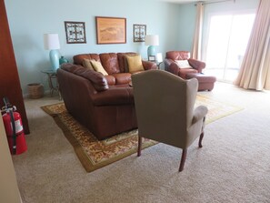 Go up some steps from kitchen to living room with 65" TV and half bath.