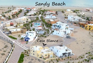 Aerial of house, community pool, and path to the beach