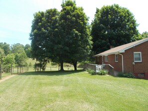 Back Side of House with Deck, Chairs, Tables, Grill, and Maple Shade Trees.