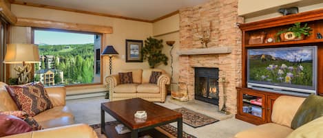 Beautifully appointed living room with wood burning fireplace and mountain views