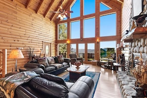 Cozy living area, stone fireplace & picturesque windows framing the view