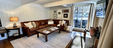 Living room, wrap around deck, leather sectional, wood burning fireplace, HDTV.