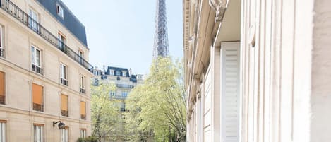 The balcony overlooks Paris streets and the beautiful Eiffel Tower.