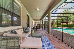 Outside lounge furniture looking out  over the pool. Full width safety fence.