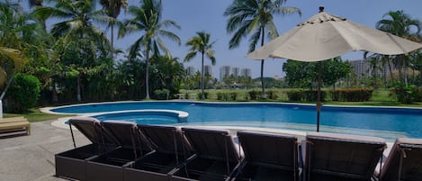 Pool area with plenty of shade, palm trees, sun loungers and wonderful views! 