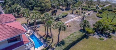 Aerial view of rear of home showing pool and ocean proximity.
