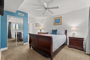 Master bedroom with queen sleigh bed, smart TV, dressers, closet & ceiling fan. 