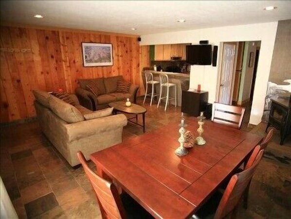 Cozy living room with views, tv, internet, wood stove, dining room table, patio