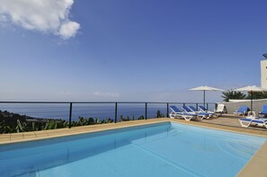 Private outdoor swimming pool with large sunbathing area. 