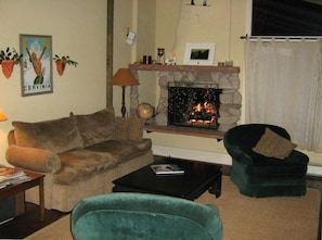 Living room with gas fireplace/hearth, pull-out sofa, chairs, coffee table