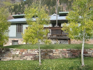 View from the south (front), with yard and wooden deck.
