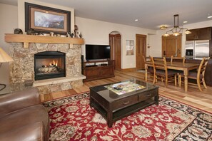 Living Room with moss rock fireplace, HDTV and queen sofa bed.