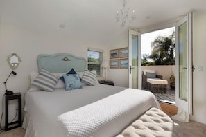 The romantic bedroom shares an orthopedic king bed and a private veranda.