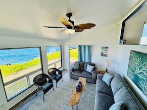 View of living room on ground level, walking down the stairs from front door.