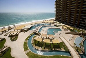 Relax and unwind on the oversized balcony overlooking the resort pools and ocean