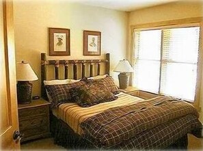 Queen Bed with feather comforter in bedroom