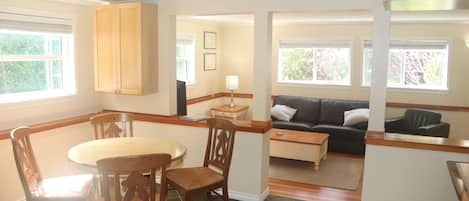 Dining area opening into bright living room with a garden view