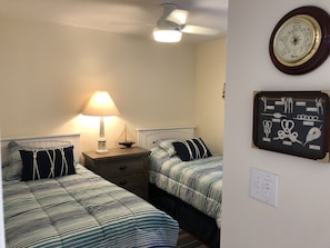 Second bedroom twin beds, lighted ceiling fan, and plantation shutters
