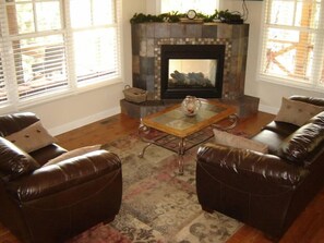 Main floor living room open to kitchen and dining room with see-thru fireplace out to deck.